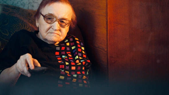 Elderly Woman In Glasses Watching Tv And Changing 