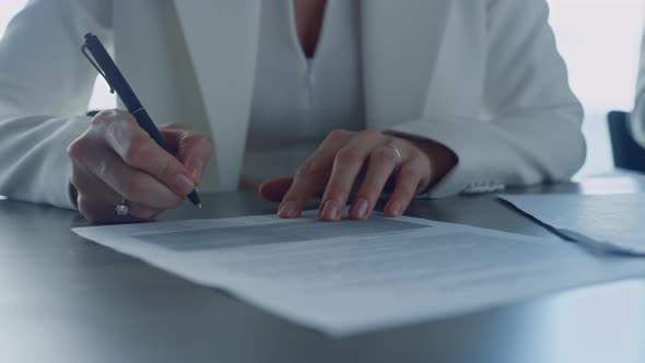 Closeup Woman Signing Contract in Suit