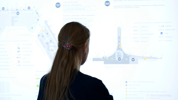 Woman Exploring Schematic Map At The Airport 
