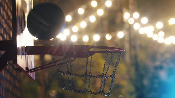 Basketball Ball Getting in the Hoop on Outdoor Playground at Night alt