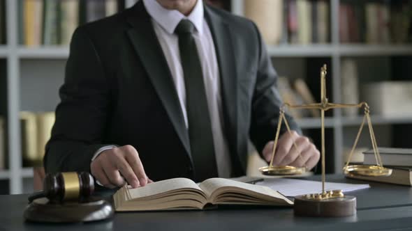 Close Up Shoot of Lawyer Hands Reading Book on Court Desk