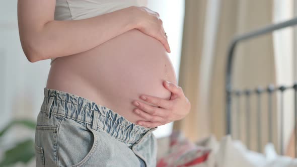 Close Up of Pregnant Woman Holding Her Big Tummy Abdomen