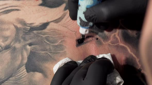 Cropped Macro Shot of a Tattooist Using Tattoo Machine