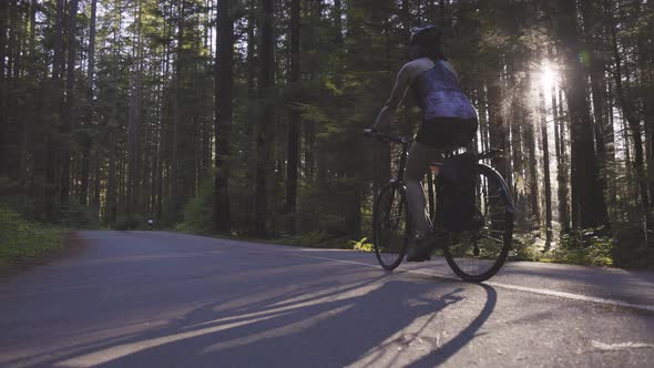 Adventurous Woman Bike Riding on a Trail in Forest