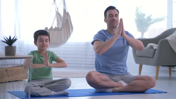 Dad and Son Using Breathing Yoga Practices at Home