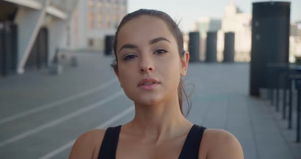 Portrait of Young Pretty Athletic Woman in Sportswear Standing Outdoors on Urban Background Posing