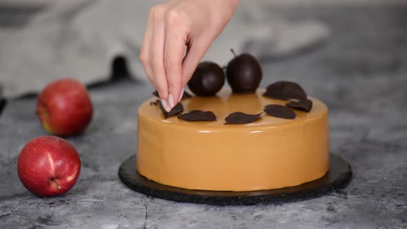 Pastry Chef Decorating the Mousse Cake with Small Chocolate Pieces. Pastry Chef Decorated Modern