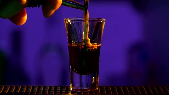 Barman Continue Pouring Clear Alcohol Liquid, Milk Liquor, Into a Glass, Shots, Slow Motion, Close
