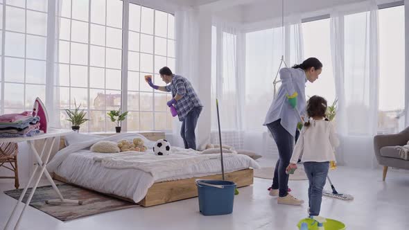 Family with Children Cleaning House Together