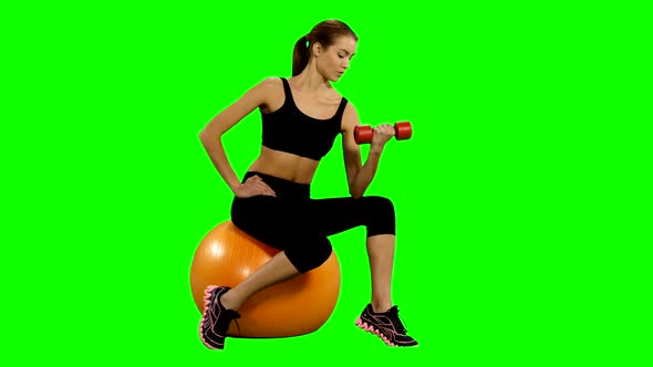 Girl Sitting on Pilates Ball and Exercising with Dumbbells. Green Screen