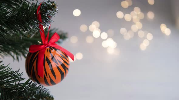 Christmas balls painted as tiger stripes on Christmas tree with a garland.