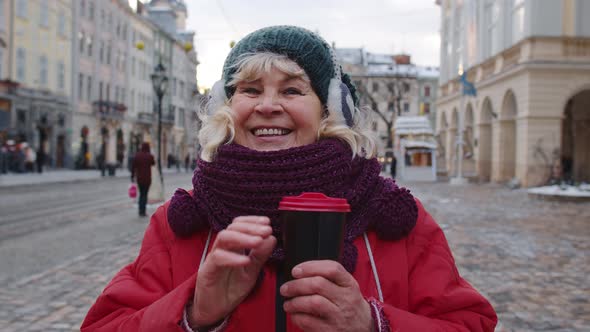 Senior Woman Grandmother Tourist Smiling Showing Thumb Up in Winter City Center of Lviv Ukraine