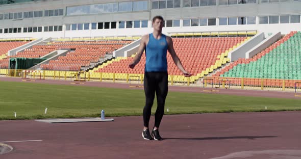 Sportsman Jumping with Rope on Stadium