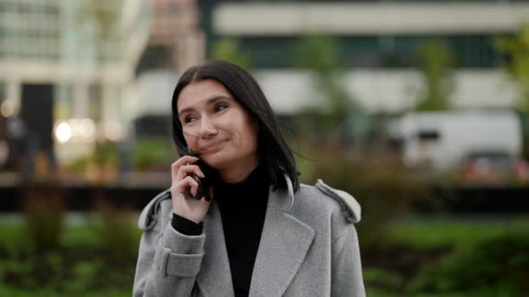 Cheerful Businesswoman is Talking By Cell Phone with Her Family During Break in Working Day