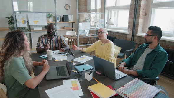 Group of Diverse Coworkers Talking at Business Meeting