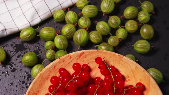 Delicious Red Cranberry and Juicy Green Gooseberry on a Black Stone Table