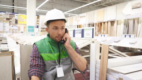 Warehouse Worker Concentrated in Conversation on Phone