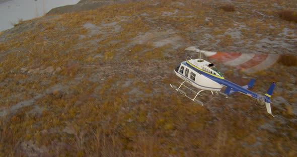 Aerial helicopter shot of Alaksan wilderness at dusk, twisting past mountain peaks, drone footage