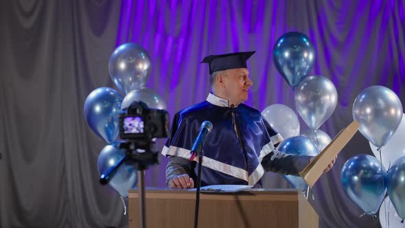 Male University Teacher Happily Congratulates Graduates on the End of Academic Year and Presents