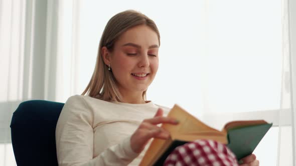 Smiling blonde woman reading book