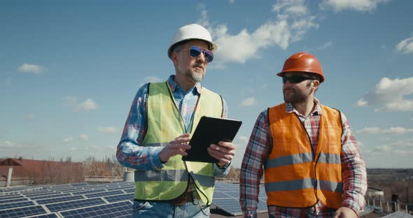 Engineer and Technician Discussing Between Solar Panels