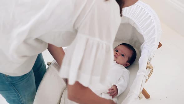 Mother placing baby in bassinet