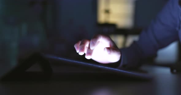 Girl is using a digital tablet at night 