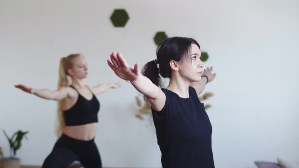 Woman does stretching for good health in yoga class with an instructor, side view.