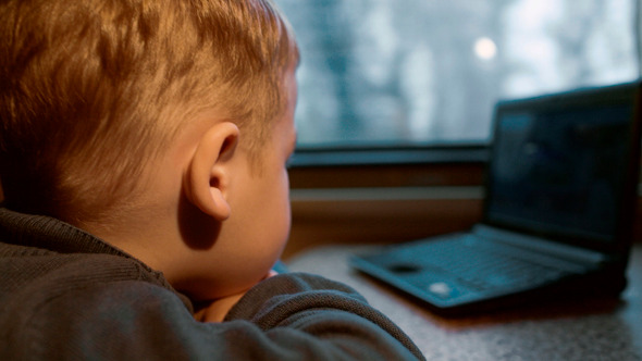 Little Boy Watching Video On Laptop In The Train