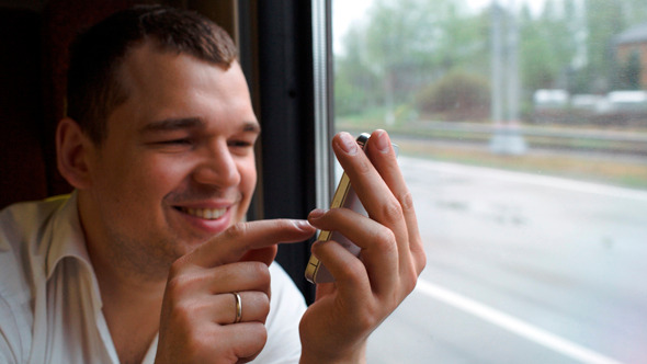 Young Man Typing Sms In Moving Train