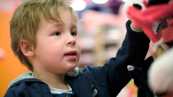 Little Child Choosing Soft Toys In The Shop