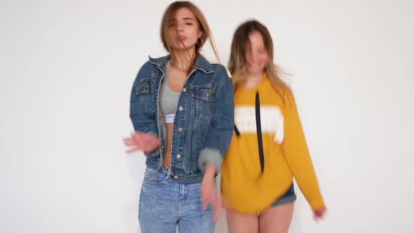 Two carefree young girls going crazy. Women in hipster summer clothes in studio
