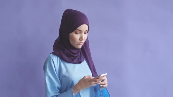 Smartphone in the Hands of a Beautiful Arabian Woman Wearing a Hijab