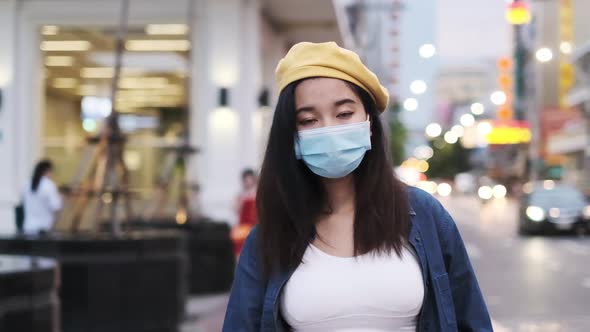 Asian woman standing outdoor wearing protective mask, covid-19 world pandemic