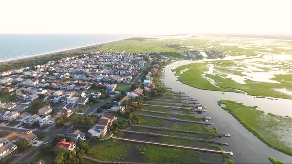 Drone shot of Ocean Isle Beach at sunset near the causeway overlooking piers and houses on the water