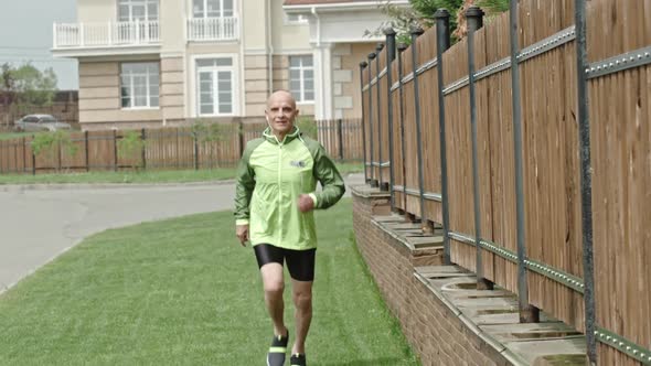 Senior Athlete Jogging with Earphones in Slowmo
