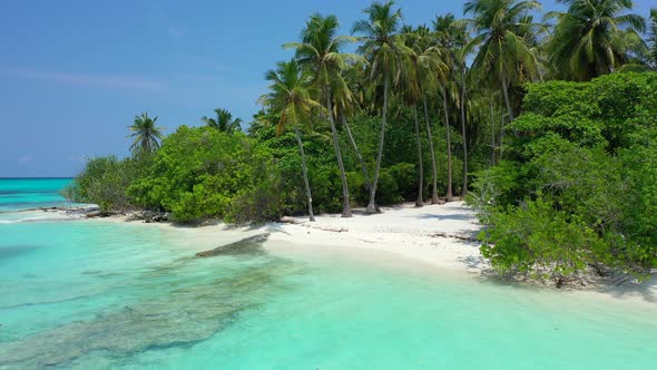 Wide angle flying travel shot of a white paradise beach and aqua blue ocean background in high resol