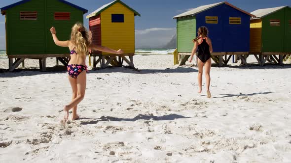 Siblings running on beach 