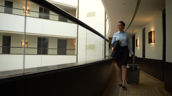Confident Woman Walking Along Inner Hotel Balcony