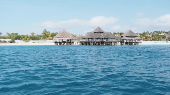 African Restaurant with Thatched Roof on Wooden Poles Above the Ocean