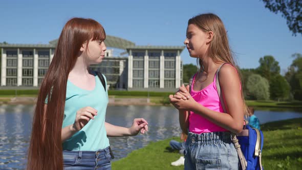 Portrait of Preteen Schoolgirls Talk Standing in Summer Park