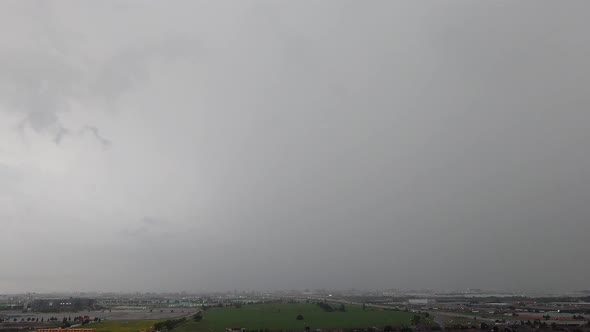 Dark rain and stormy clouds over cityscape, time lapse static view