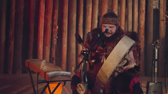 Fat Asian Man Plays Shamanic Tambourine and Sings in Cabin