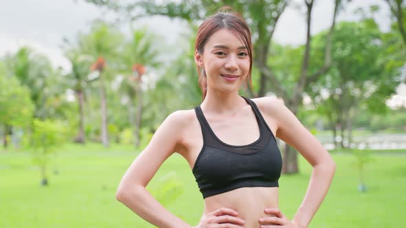 Asian active sport woman stand with confidence after exercise outdoors.