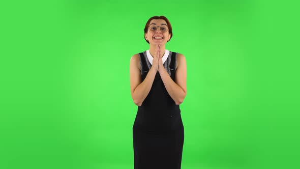 Funny Girl in Round Glasses Is Keeping Palm Together and Asking for Something. Green Screen