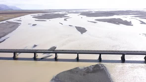 Aerial View of Cars Passing on a Bridge Road Running Through Epic River in Iceland