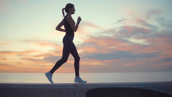 Woman Training with a Sunset on Background