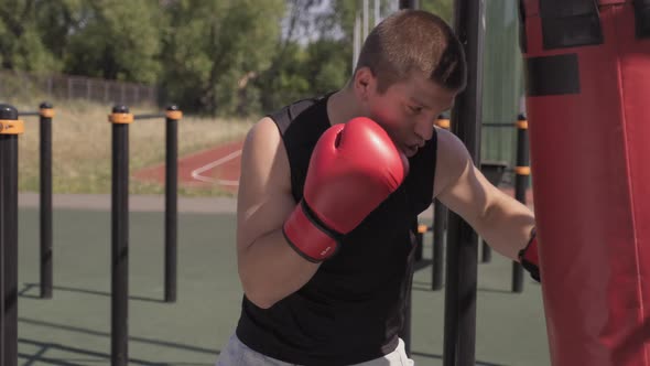 Portrait Of Man Boxing Punch Bag