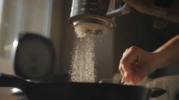 The Woman Stirs the Dough and Sifts the Flour Through a Metal Sieve