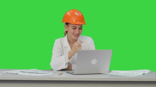 Female Construction Specialist in Hardhat Have Online Video Chat with Friend on a Green Screen